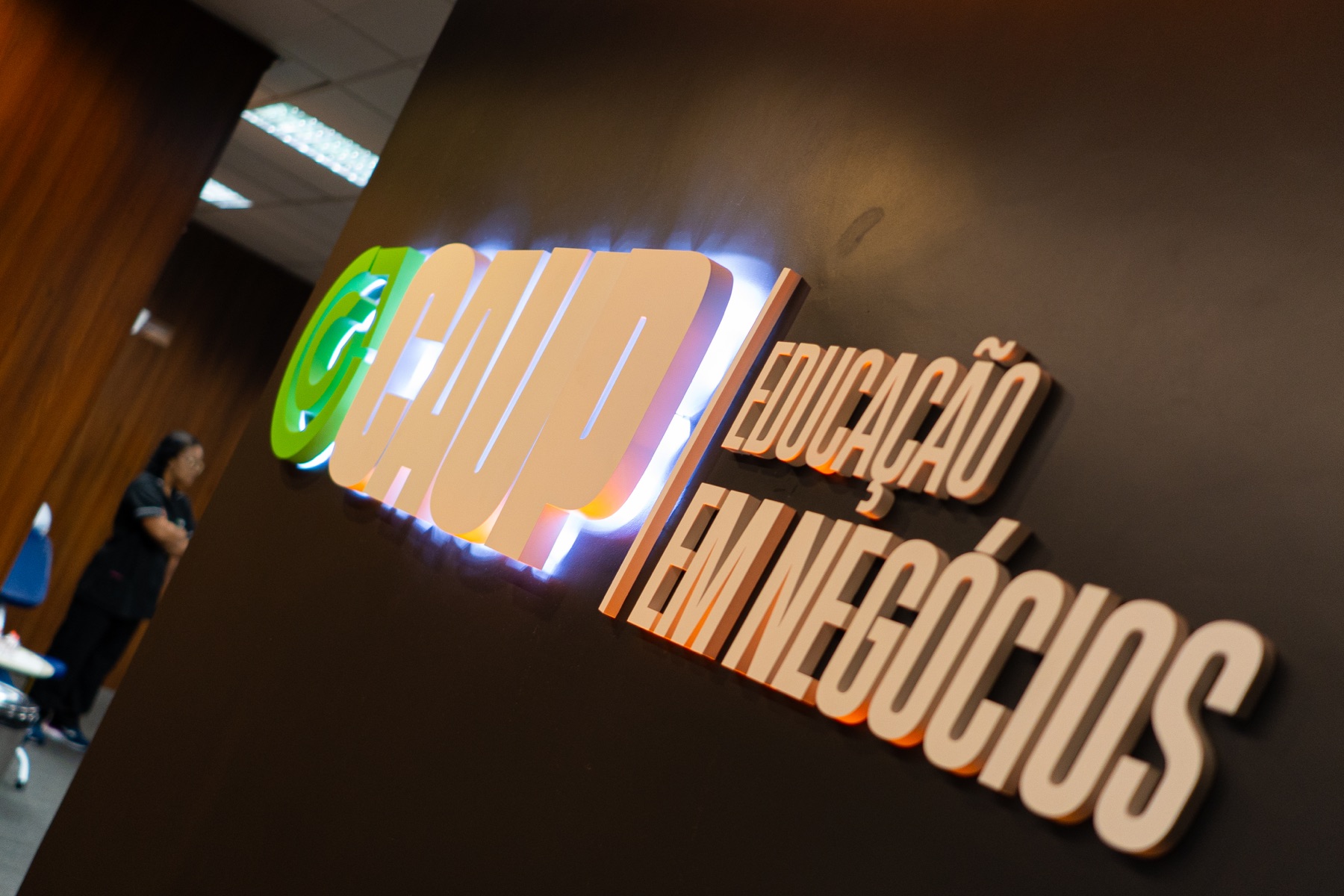 Logotipo iluminado da Capital Upgrade na parede da sede